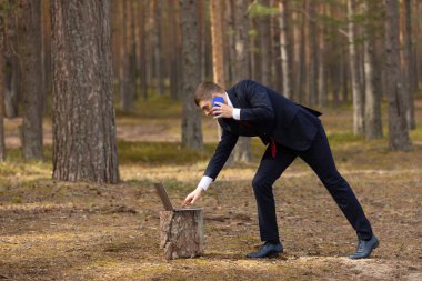 Doğada serbest çalışmak. Çam ormanında dizüstü bilgisayarda çalışan bir adam. Parktaki işadamları ofisi..