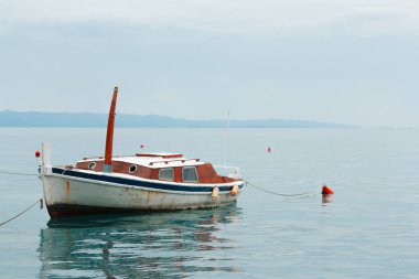eski paslı balıkçı teknesi su üzerinde boş duruyor