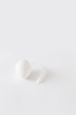 Paskalya dekorasyon minimalist beyaz yumurta ve beyaz bir arka plan üzerinde yalan beyaz tavuk tüy