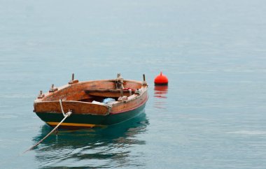 eski paslı balıkçı teknesi boş duruyor su, mavi gökyüzü ve masmavi bir deniz, yaz.