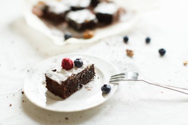 Tablo ayarı, çikolatalı tatlı kek kek çilek beyaz tabakta bir keten masa örtüsü ile kaplı bir tablo ile. 