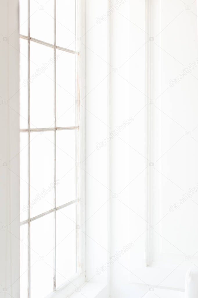 Light minimalist laconic interior with white walls, large window