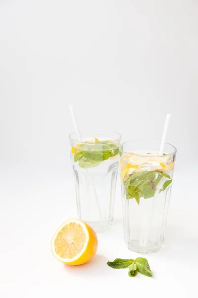 Limonada casera con agua, limón y hojas de menta en dos vasos sobre fondo blanco . —  Fotos de Stock