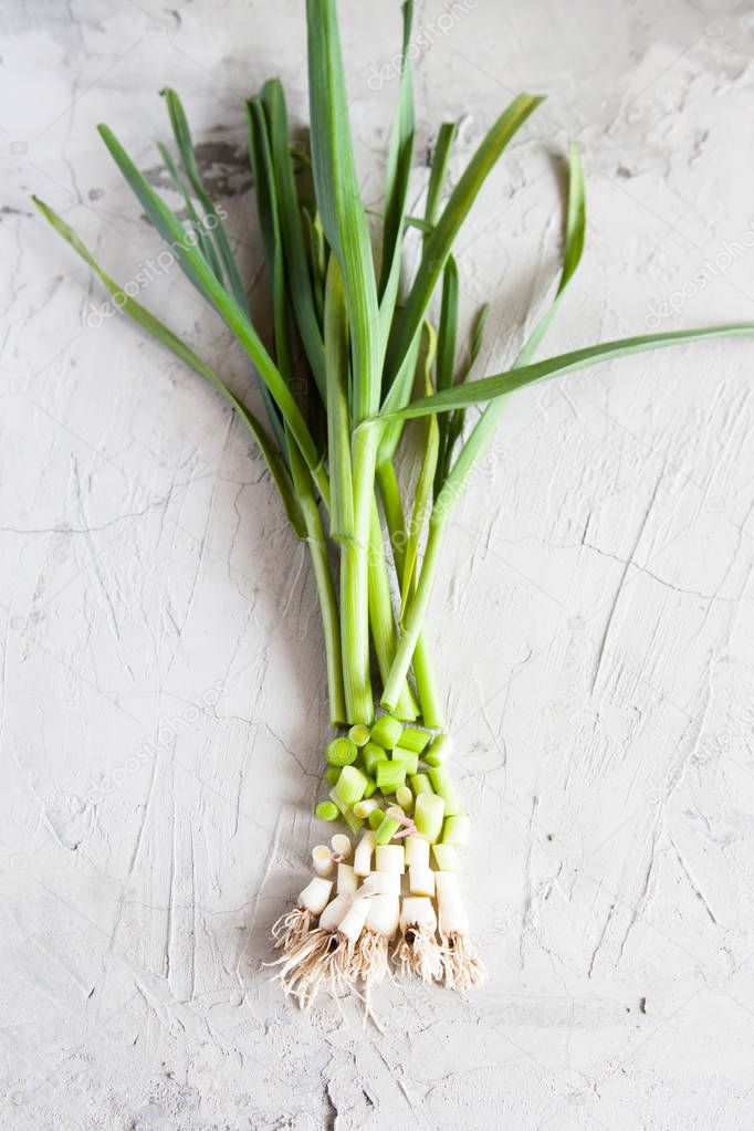 Young green garlic on a white background. Open space for your text, daylight.