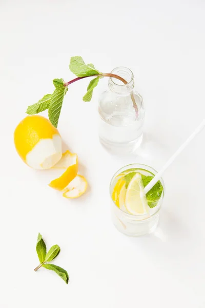 Limonada casera con agua, limón y hojas de menta en un vaso o — Foto de Stock