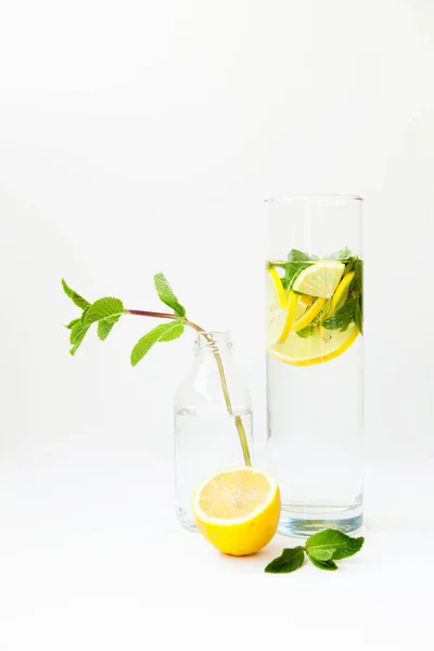 Limonada casera con agua, limón y hojas de menta en un vaso o — Foto de Stock