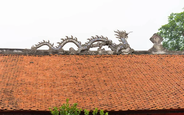 Common stone dragon on top of temple roof in Vietnam