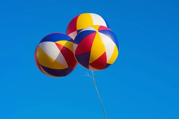 Three big balloons against blue sky