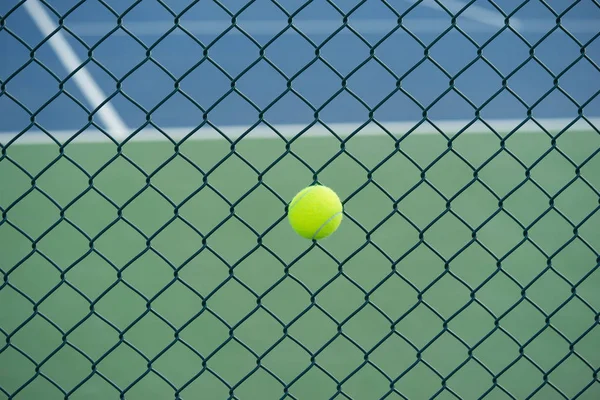 Tennis ball on metal wire against tennis court. Concept of tennis protection equipment