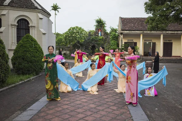 Ninh Binh, Vietnam - May 16, 2015: Vietnamese Christian women perform an old traditional dance on Flower offering to Mother day at local church