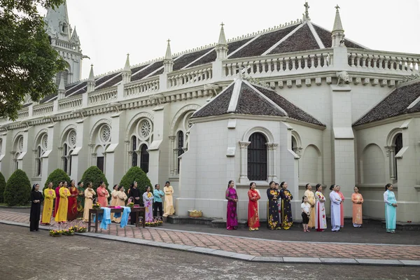 Ninh Binh, Vietnam - May 16, 2015: Vietnamese Christian women wearing traditional dress Ao Dai perform ritual at local church