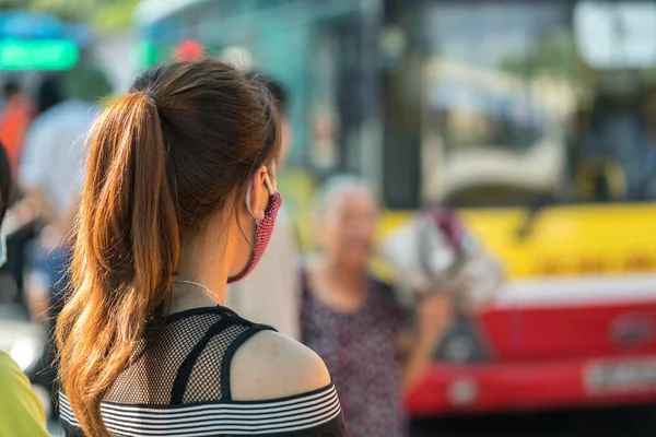 Young girl waiting for bus at bus station. Closeup.