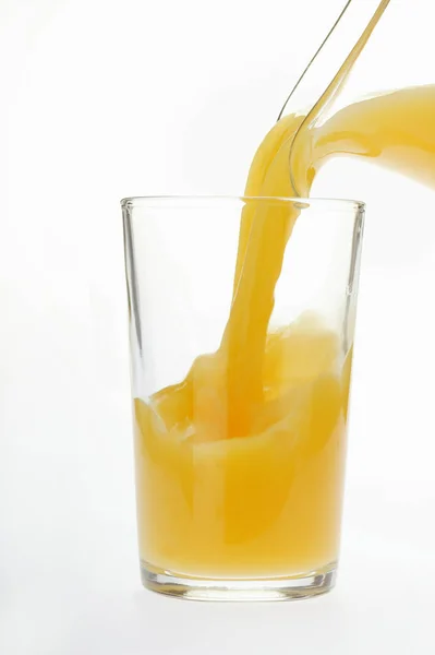 Pouring orange juice — Stock Photo, Image