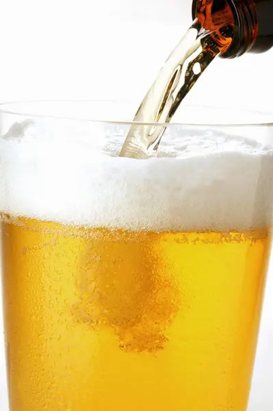 Pouring lager in glass — Stock Photo, Image