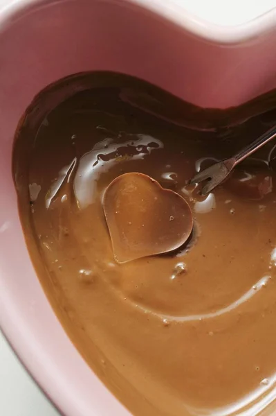 フォンデュ フォークのハート形のキャンディーとチョコレート フォンデュのクローズ アップ ビュー — ストック写真