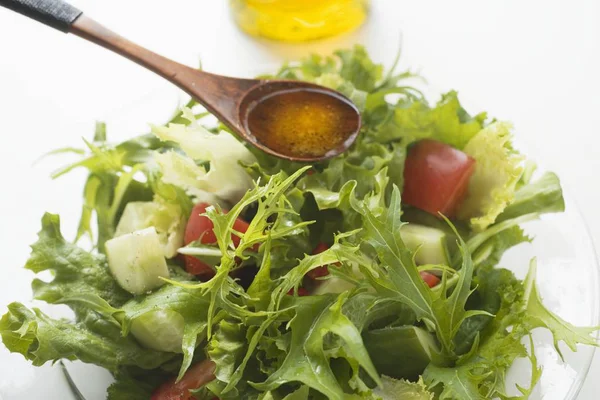 Gieten olijfolie in salade — Stockfoto