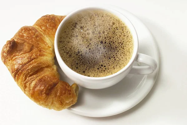 Šálek kávy a croissant — Stock fotografie
