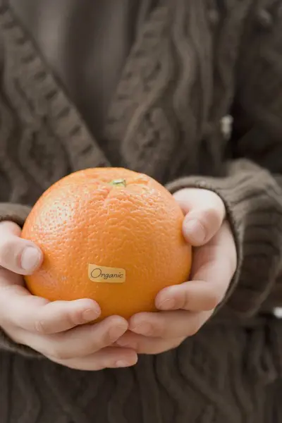 Girl holding organic orange — Stock Photo, Image