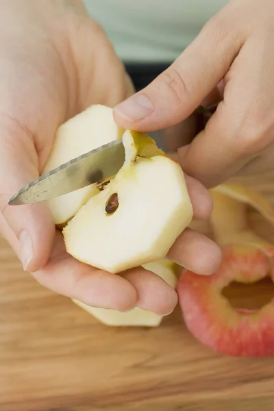 Mains féminines Couper la pomme en quartiers — Photo