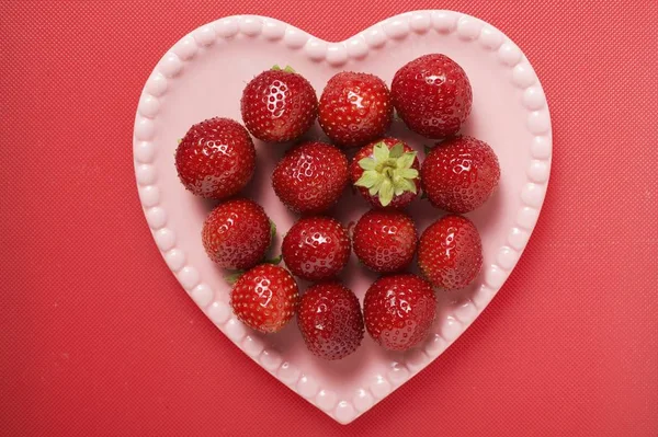 Strawberries on pink heart-shaped plate — Stock Photo, Image