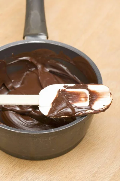 Gesmolten chocolade op spatel en in de pan — Stockfoto