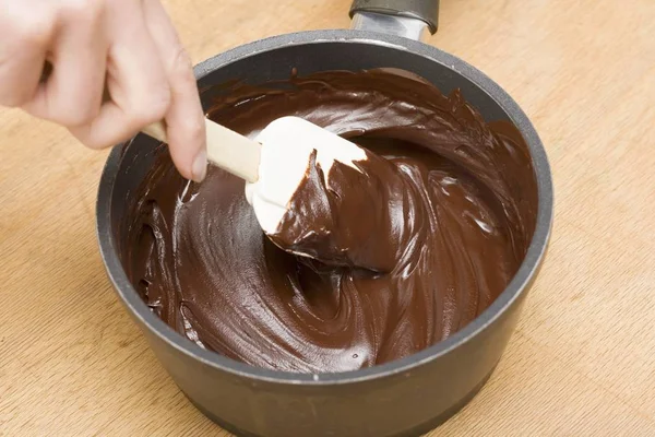 Mänsklig hand omrörning smält choklad — Stockfoto