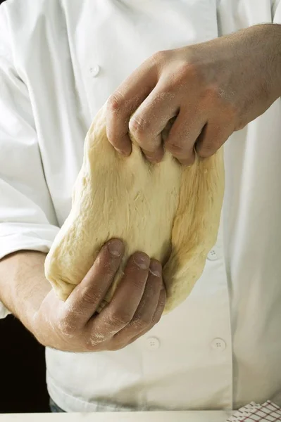 Homme pétrissant pâte à pizza — Photo