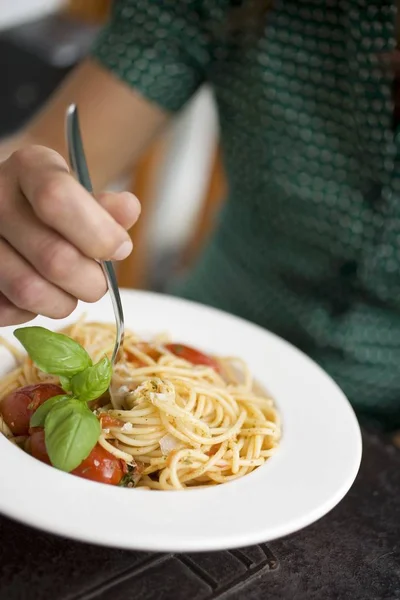 Woman eating spaghetti with tomatoes — Stock Photo, Image