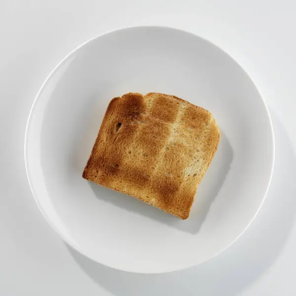 白色盘子上一片烤面包的特写顶部视图 — 图库照片