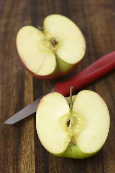 Halved apple with knife — Stock Photo, Image