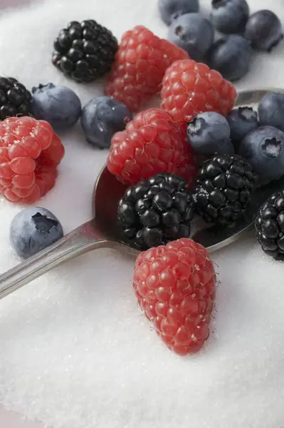 Spoon and mixed berries in sugar — Stock Photo, Image