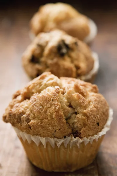 Assorted muffins on wooden surface — Stock Photo, Image