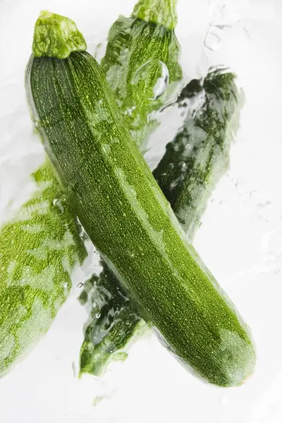 Green courgettes in water — Stock Photo, Image
