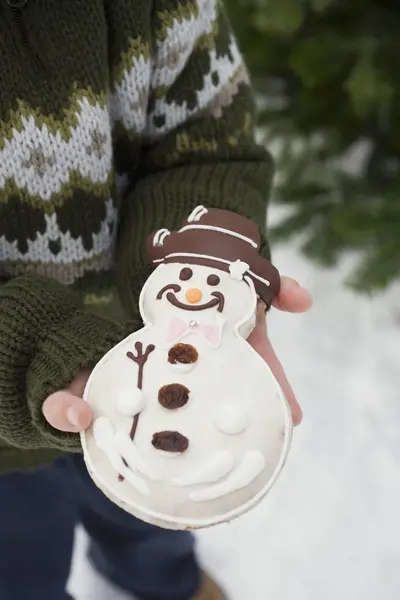 Kind hält Schneemannkeks in der Hand — Stockfoto