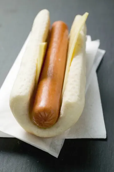 Hot dog with cheese on paper napkin — Stock Photo, Image