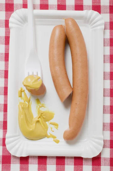 Frankfurters con senape su piatto di carta — Foto Stock