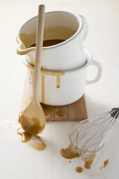 Gravy in an enamel jug with whisk — Stock Photo, Image