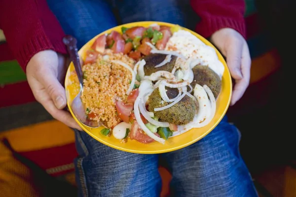 Person mit Falafel mit verschiedenen Beilagen — Stockfoto