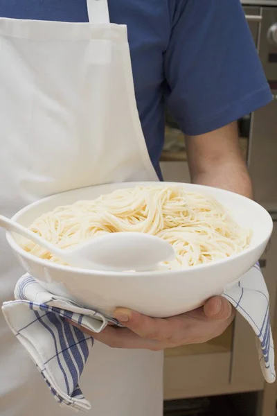 Man holding bowl of cooked spaghetti — Stock Photo, Image