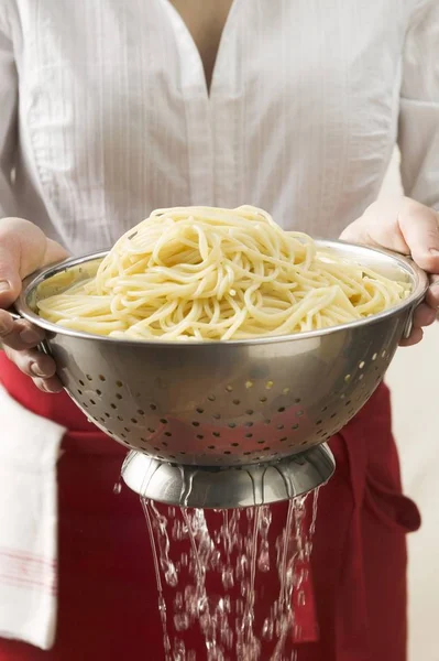 Draining cooked spaghetti — Stock Photo, Image