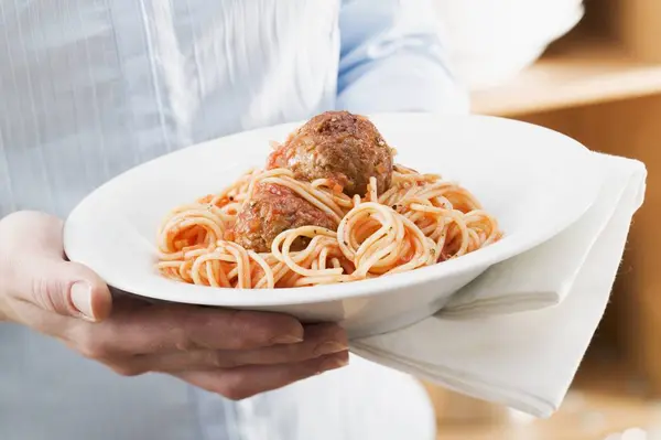 Жінка тримає тарілку спагеті — стокове фото