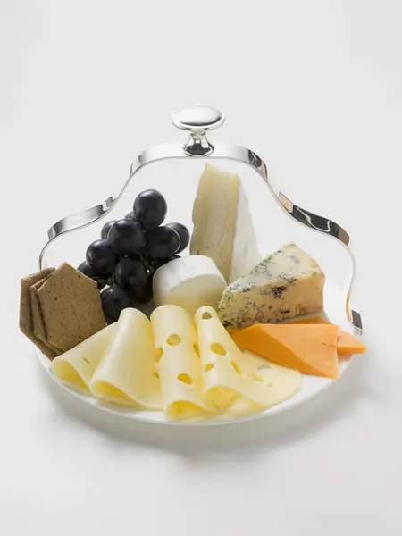 Cheese platter with red grapes — Stock Photo, Image