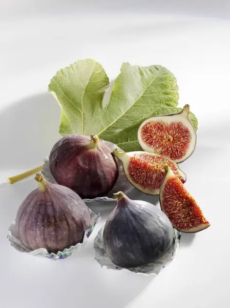 Fresh figs with slices and leaf — Stock Photo, Image