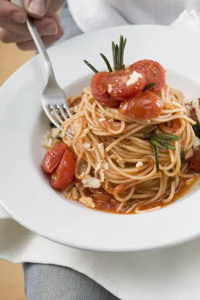 Kvinna äta spagetti med tomater — Stockfoto