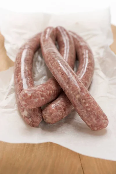 Raw sausages on paper — Stock Photo, Image