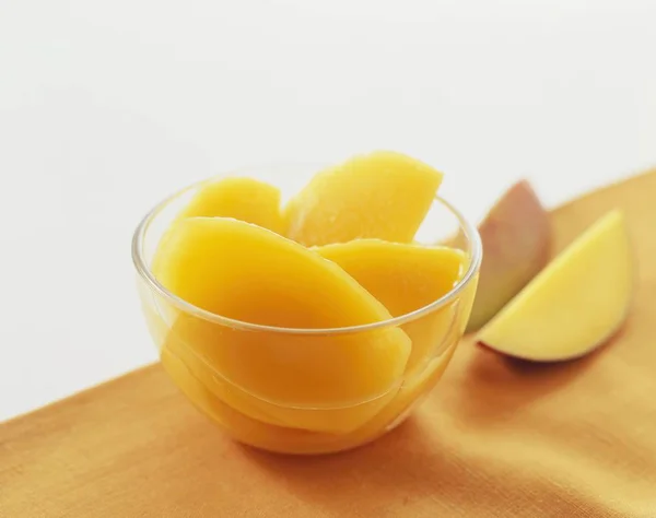 Slices of canned mango in bowl — Stock Photo, Image