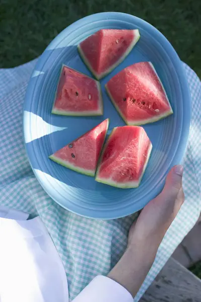 Woman holding plate of watermelon — Stock Photo, Image