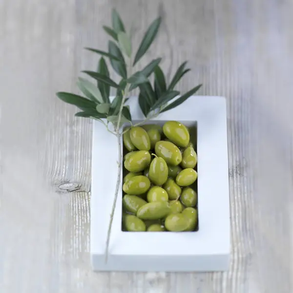 Зеленые оливки в белой чаше — стоковое фото