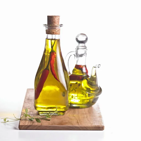 Chilli Oil Herbs Two Glass Carafes Wooden Board — Stock Photo, Image