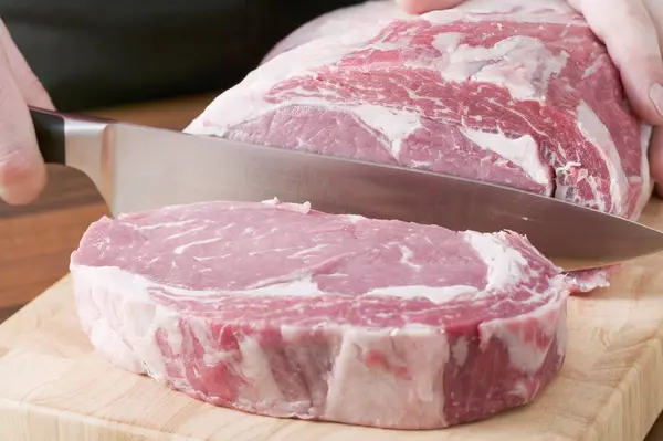 Man Slicing raw beef — Stock Photo, Image